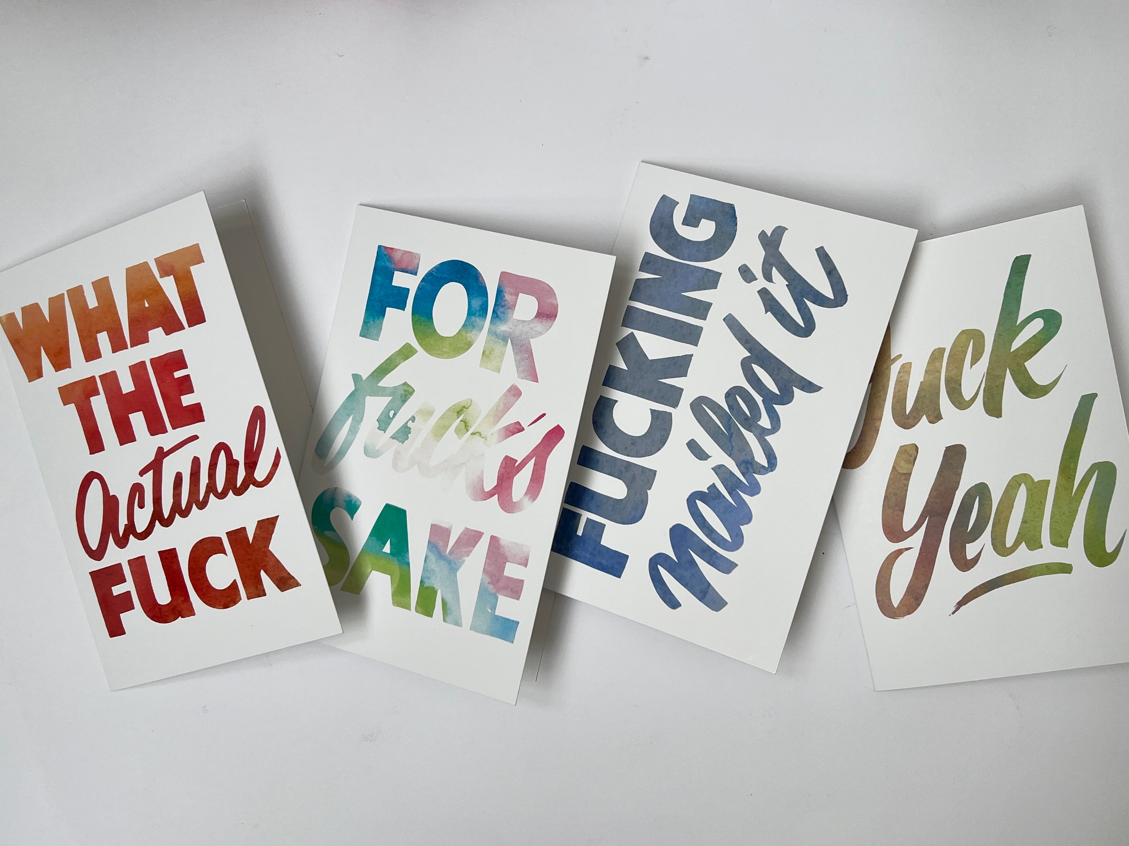 Four cards with colorful text on a white background